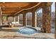 Stunning outdoor spa with stone arches, wood ceilings, and views of the lake, with stone flooring and comfortable seating area at 102 Anna Lake Ln, Cary, NC 27513