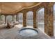 Outdoor spa with stone arches, wood ceilings, and views of the lake, with stone flooring and comfortable seating at 102 Anna Lake Ln, Cary, NC 27513
