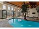 Indoor pool with palm trees, skylights, and access to an outdoor lounge area with lake view at 102 Anna Lake Ln, Cary, NC 27513