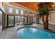 Indoor pool with a palm tree inside and windows and doors with waterfront views at 102 Anna Lake Ln, Cary, NC 27513