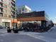 An outdoor patio seating area with a modern restaurant, Crú Food & Wine Bar, in the background at 102 Anna Lake Ln, Cary, NC 27513