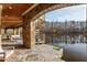 Outdoor spiral staircase leads to the lake from this stone patio with wood ceiling at 102 Anna Lake Ln, Cary, NC 27513