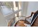 Elegant curved staircase with wood treads and large lake view windows at 102 Anna Lake Ln, Cary, NC 27513