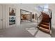 Grand foyer showcases a curved staircase, leading to a game room and living area, enhanced by natural light at 102 Anna Lake Ln, Cary, NC 27513