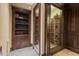 Custom wine cellar with glass doors, wooden racks, and adjacent bookcase for sophisticated storage and display at 102 Anna Lake Ln, Cary, NC 27513