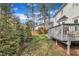 Backyard with manicured lawn, evergreen trees, and gray deck in partially shaded sunlight at 106 Ferris Wheel Ct, Cary, NC 27513