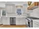 Well-lit kitchen features white cabinets, stainless steel appliances, and farmhouse sink at 106 Ferris Wheel Ct, Cary, NC 27513