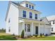 New construction two-story home with white siding, covered entryway, manicured lawn and blue sky at 106 Willow Cameron Way, Angier, NC 27501