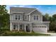 Charming two-story home with a covered porch, attached two car garage, and nicely landscaped front yard at 113 Cloud Berry Ln, Holly Springs, NC 27540