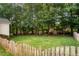 Spacious backyard with well-maintained lawn, bordered by trees and a wooden fence at 116 Wright Hill Dr, Durham, NC 27712