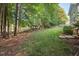 Large grassy backyard with mature trees and a charming gazebo for outdoor relaxation at 116 Wright Hill Dr, Durham, NC 27712