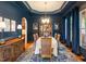 Sophisticated dining room with dark blue walls, elegant chandelier, and formal setting at 116 Wright Hill Dr, Durham, NC 27712