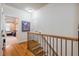 Upstairs hallway with hardwood floors, wood railing and access to rooms at 116 Wright Hill Dr, Durham, NC 27712