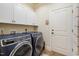 Spacious laundry room with modern washer and dryer, white cabinets, and tile floor at 116 Wright Hill Dr, Durham, NC 27712