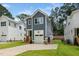 Side view of a two-story home with a blue exterior, showcasing the driveway and adjacent green lawn at 1211 Chaney Rd, Raleigh, NC 27606