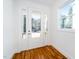 Bright foyer featuring hardwood floors, a glass door, and a large window overlooking the yard at 1211 Chaney Rd, Raleigh, NC 27606