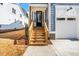 Close-up of a home's entrance with a wood staircase, glass door, and a view of the yard at 1211 Chaney Rd, Raleigh, NC 27606