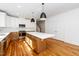 Bright kitchen features a large island, modern stainless steel appliances, and hardwood floors at 1211 Chaney Rd, Raleigh, NC 27606