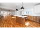 Open-concept kitchen with large island, stainless steel appliances, and hardwood flooring at 1211 Chaney Rd, Raleigh, NC 27606