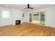 Bright living room featuring a modern fireplace, hardwood floors, and sliding glass doors to the outdoor space at 1211 Chaney Rd, Raleigh, NC 27606