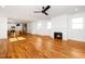 Open floor plan with a fireplace, hardwood floors, and a view into the kitchen area at 1211 Chaney Rd, Raleigh, NC 27606