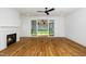 Bright living room showcasing a fireplace, hardwood floors, ceiling fan, and seamless access to the backyard at 1211 Chaney Rd, Raleigh, NC 27606