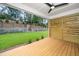 Covered porch showcasing modern horizontal wooden fence, ceiling fan, and access to the landscaped backyard at 1211 Chaney Rd, Raleigh, NC 27606