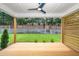 Covered porch boasting a ceiling fan, wooden floor, modern horizontal wooden fence, and backyard access at 1211 Chaney Rd, Raleigh, NC 27606
