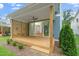 Covered porch displaying a ceiling fan, wooden floor, modern horizontal fence, and sliding door entry to living room at 1211 Chaney Rd, Raleigh, NC 27606