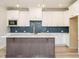 Modern kitchen with white cabinets, quartz countertops, stylish backsplash, and a functional island at 1245 Barreto Dr, Wendell, NC 27591
