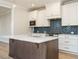 Modern kitchen featuring an island, stainless steel appliances, and stylish blue backsplash at 1245 Barreto Dr, Wendell, NC 27591