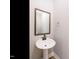 Pedestal sink in half bath with a wood-framed mirror and brushed bronze fixtures at 1245 Barreto Dr, Wendell, NC 27591