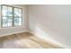 Sunlit room with hardwood floors, white trim, and a large window offering a view at 1245 Barreto Dr, Wendell, NC 27591