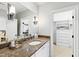 Elegant bathroom vanity with granite countertops, a sleek sink, and access to a spacious walk-in closet at 1416 Barony Lake Way, Raleigh, NC 27614