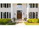 Close up of stately brick home entrance with double wood doors and lush foliage at 1416 Barony Lake Way, Raleigh, NC 27614