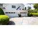 Attached three-car garage with white doors and manicured landscaping at 1416 Barony Lake Way, Raleigh, NC 27614