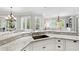 Modern kitchen features a granite countertop island with a sink, white cabinets, and hardwood floors at 1416 Barony Lake Way, Raleigh, NC 27614