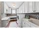 Well-lit laundry room with sink, front-loading washer/dryer, ample cabinets and tiled backsplash at 1416 Barony Lake Way, Raleigh, NC 27614