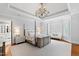 Spacious main bedroom featuring a tray ceiling, chandelier, and natural light at 1416 Barony Lake Way, Raleigh, NC 27614