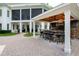 Outdoor kitchen and bar area with bar seating, grill, and brick flooring at 1416 Barony Lake Way, Raleigh, NC 27614