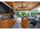 Covered outdoor kitchen featuring a stainless steel grill, bar seating, and wood ceiling at 1416 Barony Lake Way, Raleigh, NC 27614