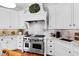 Gourmet kitchen featuring high-end stainless steel appliances and custom white cabinetry at 1416 Barony Lake Way, Raleigh, NC 27614