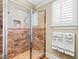 Beautifully tiled shower with a glass door and convenient shelving, complemented by natural light and towel racks at 1416 Barony Lake Way, Raleigh, NC 27614