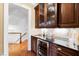 Stylish wet bar featuring wood cabinets, granite countertops, and a wine cooler at 1416 Barony Lake Way, Raleigh, NC 27614