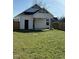 Rear view of the home featuring a large, green backyard with wood fencing at 151 E Washington St, Coats, NC 27521