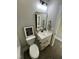 Modern bathroom with a vanity, mirror, and light fixture, plus a toilet and framed art at 151 E Washington St, Coats, NC 27521