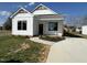 Charming new construction featuring a covered porch, black windows, and a manicured lawn at 151 E Washington St, Coats, NC 27521