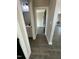 Hallway with hardwood floors, white trim, leading to a bathroom and living area at 151 E Washington St, Coats, NC 27521