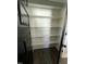 White shelved pantry with modern, dark-colored door and dark hardwood flooring at 151 E Washington St, Coats, NC 27521
