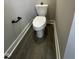 Modern powder room with wood-look floors, gray walls, and black hardware at 151 E Washington St, Coats, NC 27521